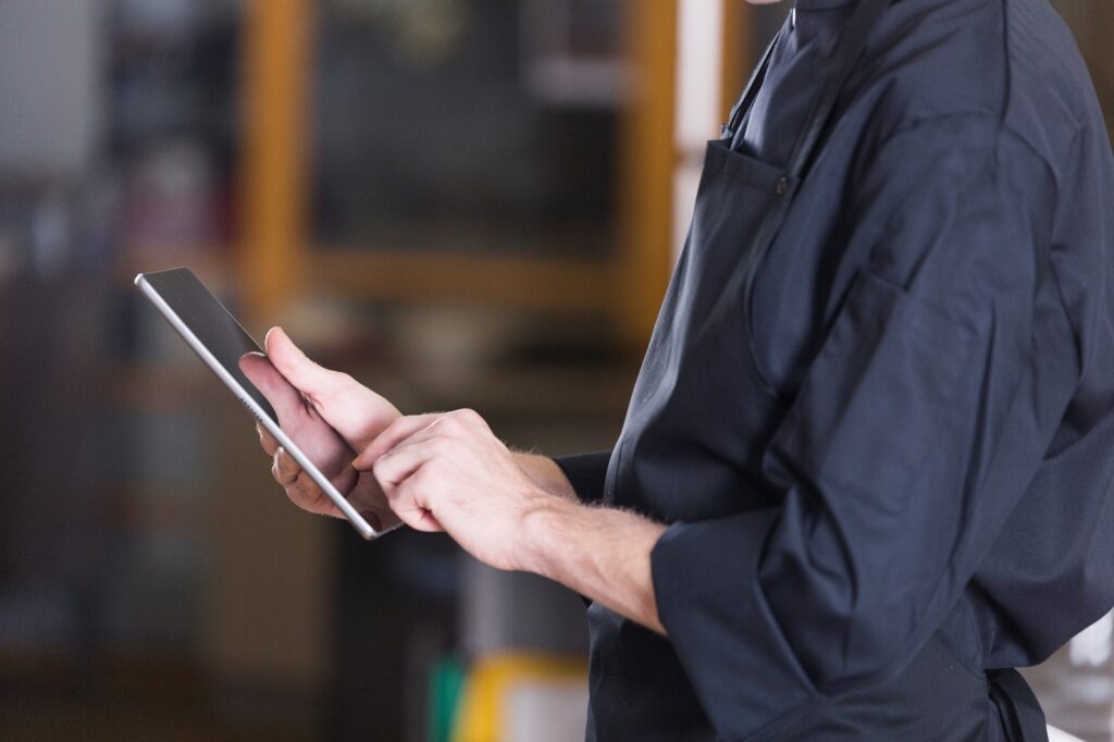 uomo in camicia nera consulta un tablet