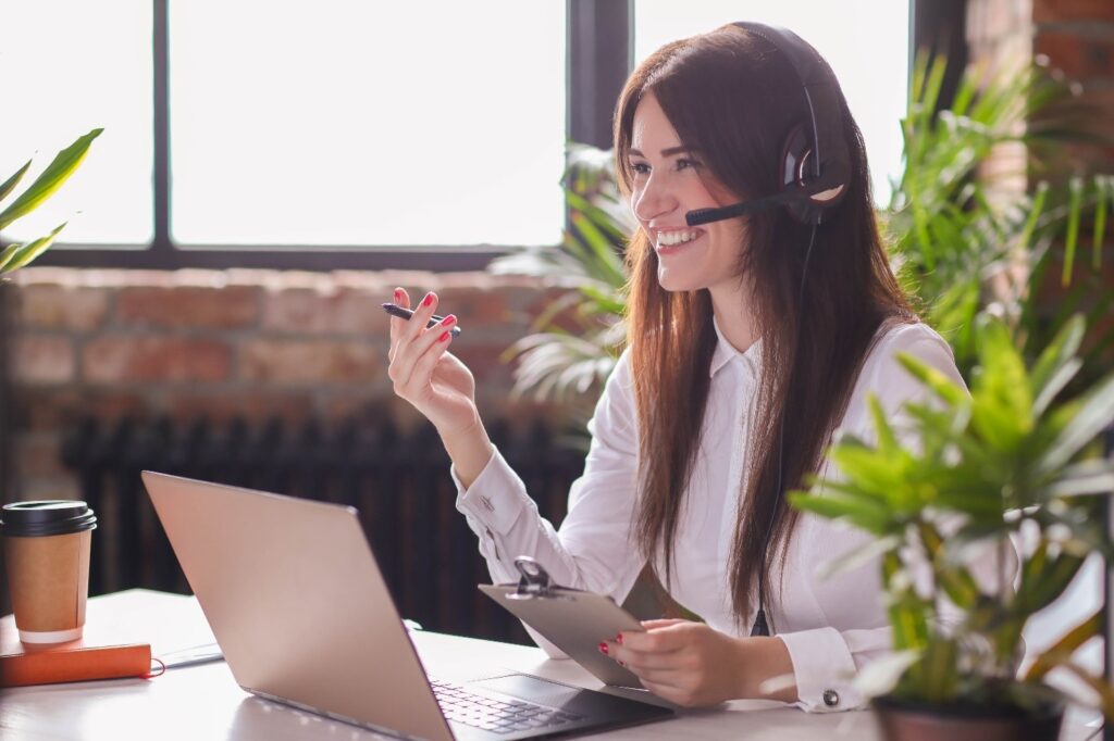 donna con cuffie e microfono lavora al pc facendo customer care